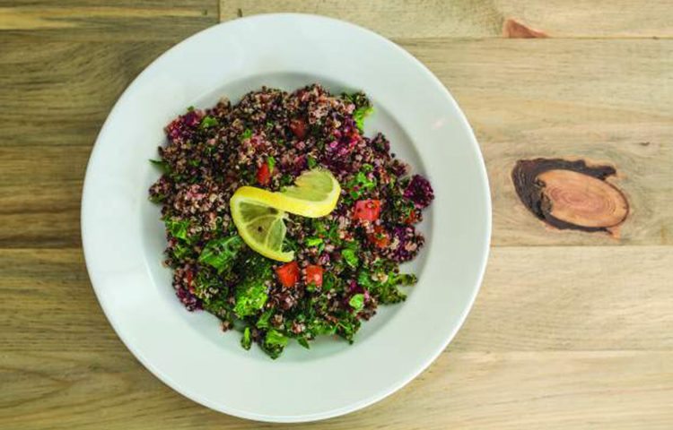 A quinoa bowl with broccoli, kale, beets and tomatoes